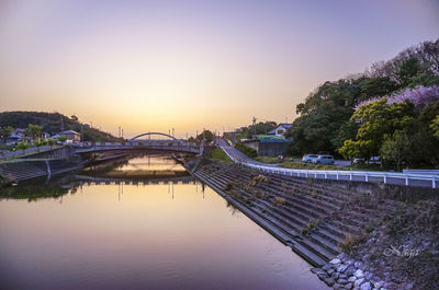 Bridge over river against sky during sunset