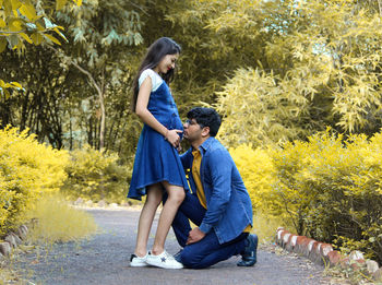 Side view of a siblings standing against plants