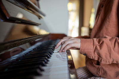 Midsection of woman playing piano