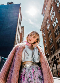 Low angle portrait of woman against building