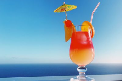 Close-up of drink in glass against blue sky