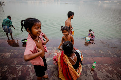 People and boys standing in water