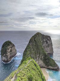 Rock formation by sea against sky