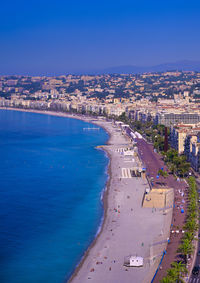 High angle view of buildings by sea against blue sky