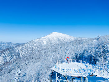 Man looking at snowcapped mountain while standing on observation point