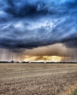 Scenic view of agricultural field against sky during sunset