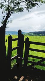 Scenic view of field against cloudy sky