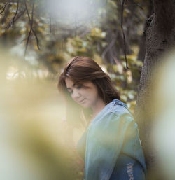 Young woman looking down in forest