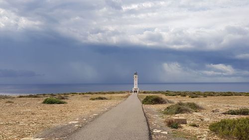 Lighthouse amidst sea against sky