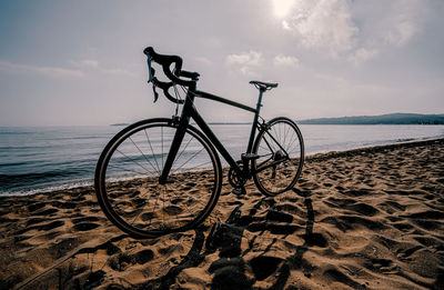 Bicycle on beach against sky