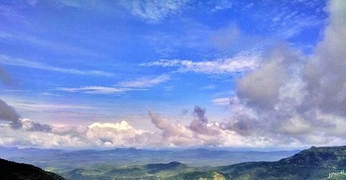 Scenic view of mountains against cloudy sky