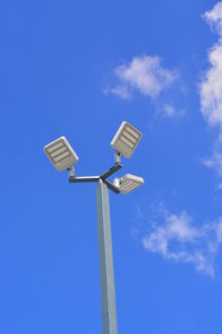 Low angle view of floodlight against blue sky