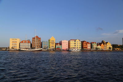 Sea by city against clear sky