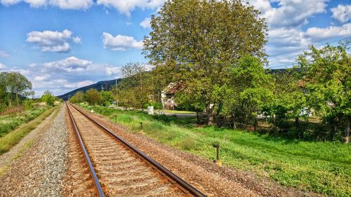 Railroad track against cloudy sky