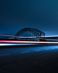 Bridge over river against sky at night