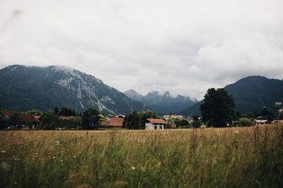 Scenic view of field by mountains against sky