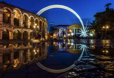 Reflection of buildings in lake at night