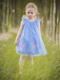 Portrait of cute girl walking on grassy field