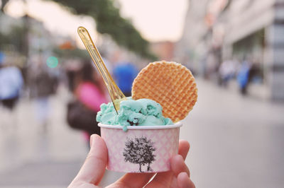 Cropped image of hand holding ice cream on street