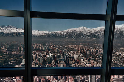 Cityscape against sky seen through glass window