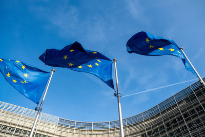 Low angle view of flags against blue sky