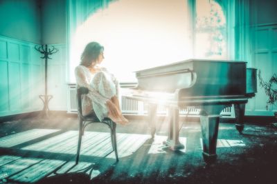 Full length of woman sitting on chair at home