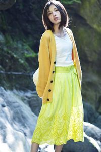 Beautiful young woman standing against yellow outdoors