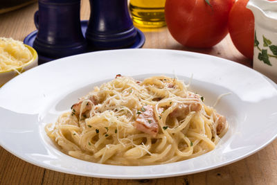 High angle view of spaghetti with carbonara in plate on table