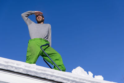 Low angle view of man against blue sky