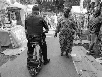 Rear view of people walking on road