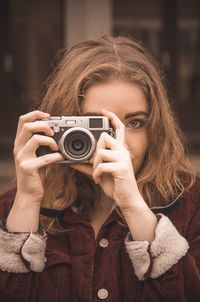 Portrait of woman photographing outdoors