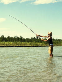 Side view of a fisherman casting into the river