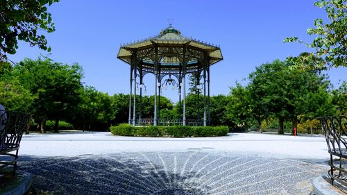 Gazebo in park against clear blue sky