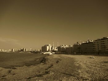 Road by buildings against sky in city