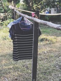 Close-up of clothes drying on wooden post on field