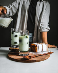 Midsection of man pouring drink in glass