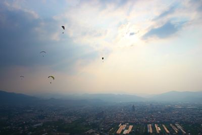 Aerial view of city against cloudy sky