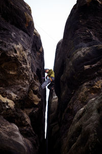 Low angle view of man amidst mountains against sky