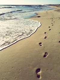 Footprints on sand at beach