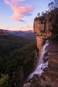 Scenic view of waterfall against sky