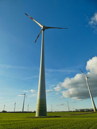 Low angle view of windmill on field against sky