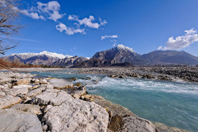 Scenic view of sea and mountains against sky