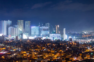 Illuminated cityscape against sky at night