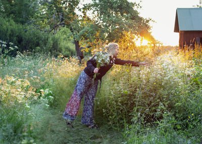 Smiling woman picking wildflowers