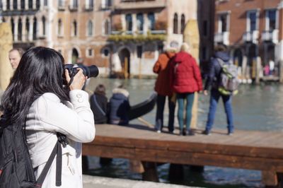 Rear view of woman photographing water