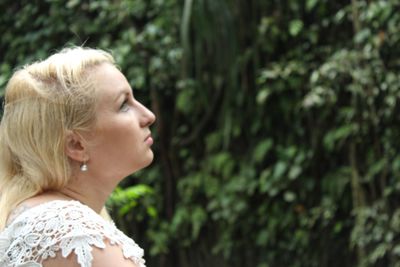 Woman looking away against plants