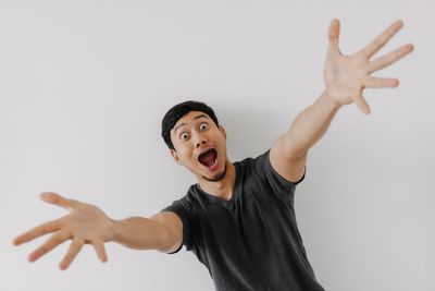 Young woman gesturing against white background