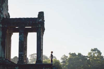 Side view of woman at old ruins in forest