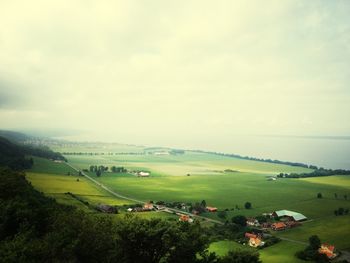 Scenic view of grassy field against cloudy sky