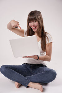 Portrait of young woman sitting on railing